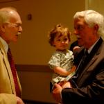 BOB founder, Bob Marckini holds his granddaughter and speaks to Loma Linda historian, Dick Schaefer.